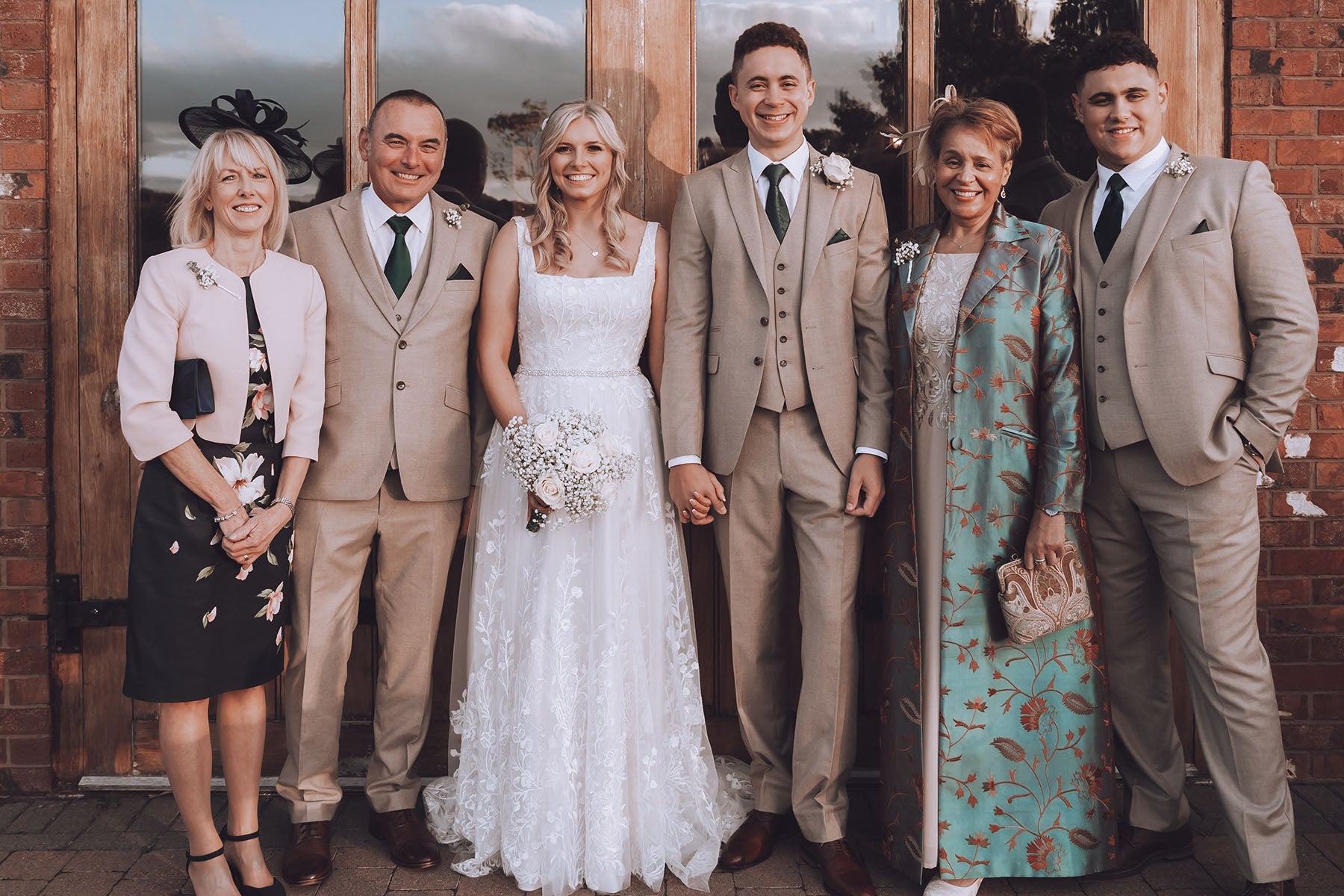 Mother of the groom wearing long blue silk coat at her sons wedding.