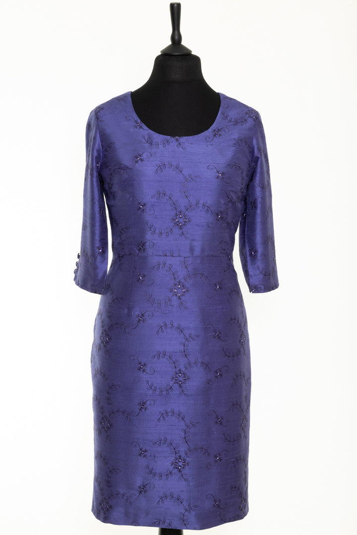 Women's dress with round neck and longer sleeves. This dress is blue, periwinkle with soft floral embroidery. 