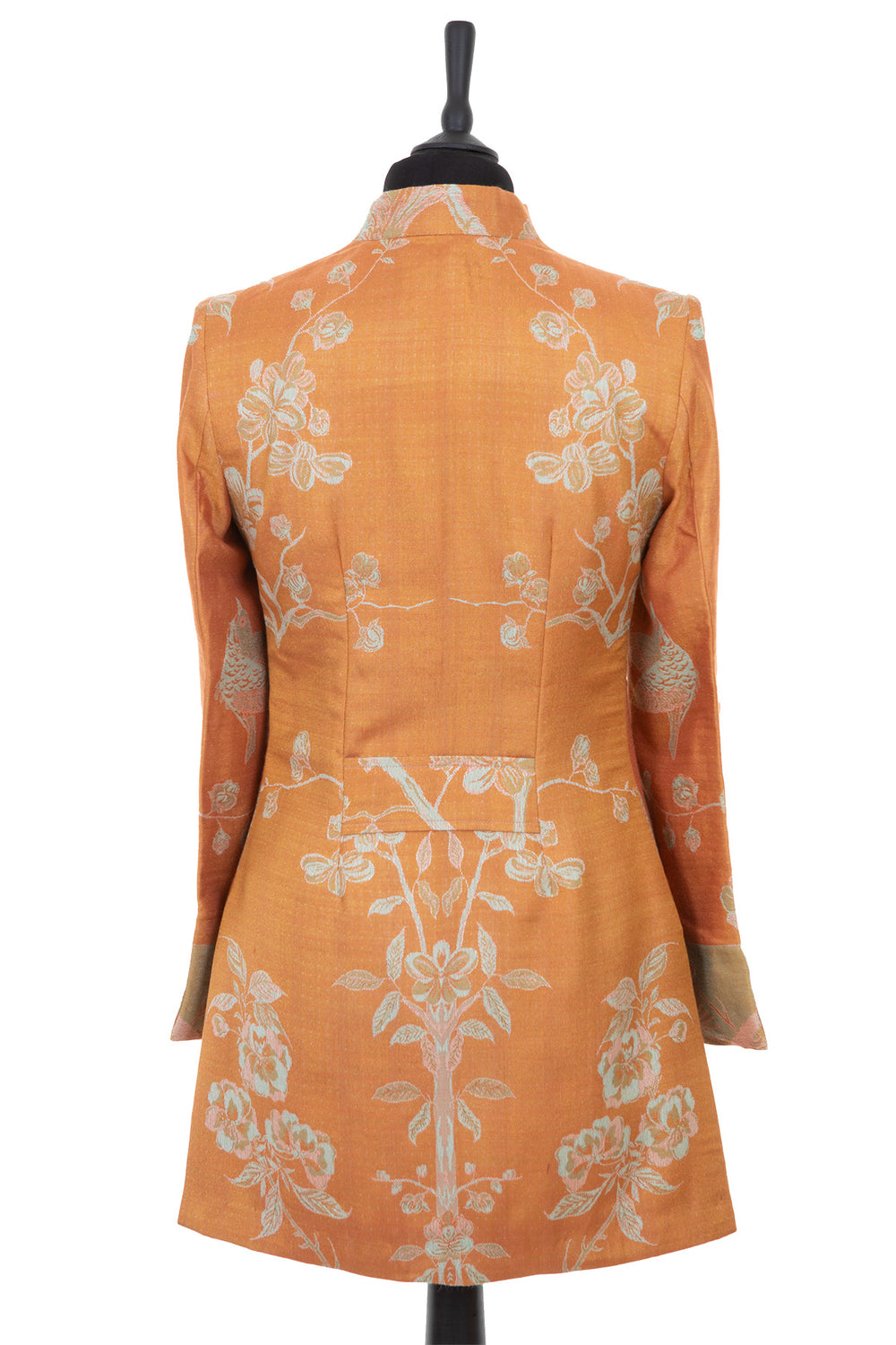 Womens longline jacket with a soft curved collar and half belt, in an apricot orange cashmere fabric with a pale green pattern