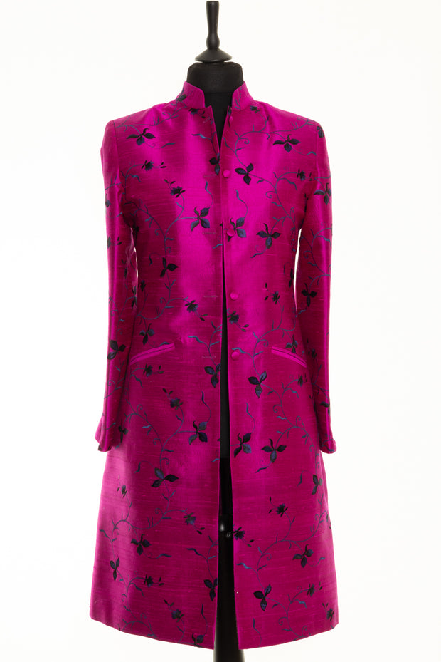 Bright pink coat with blue and black embroidery. 