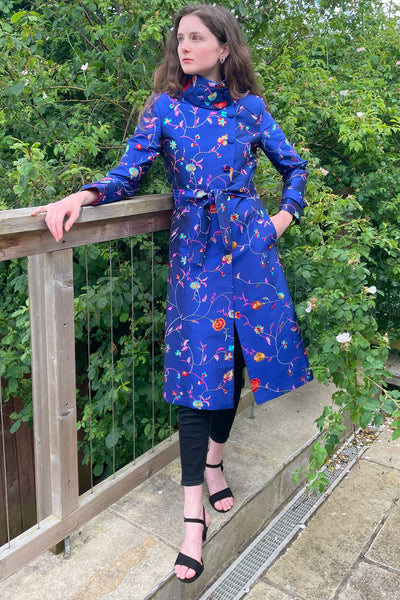 Trench coat in blue silk fabric. Floral pattern coat. 