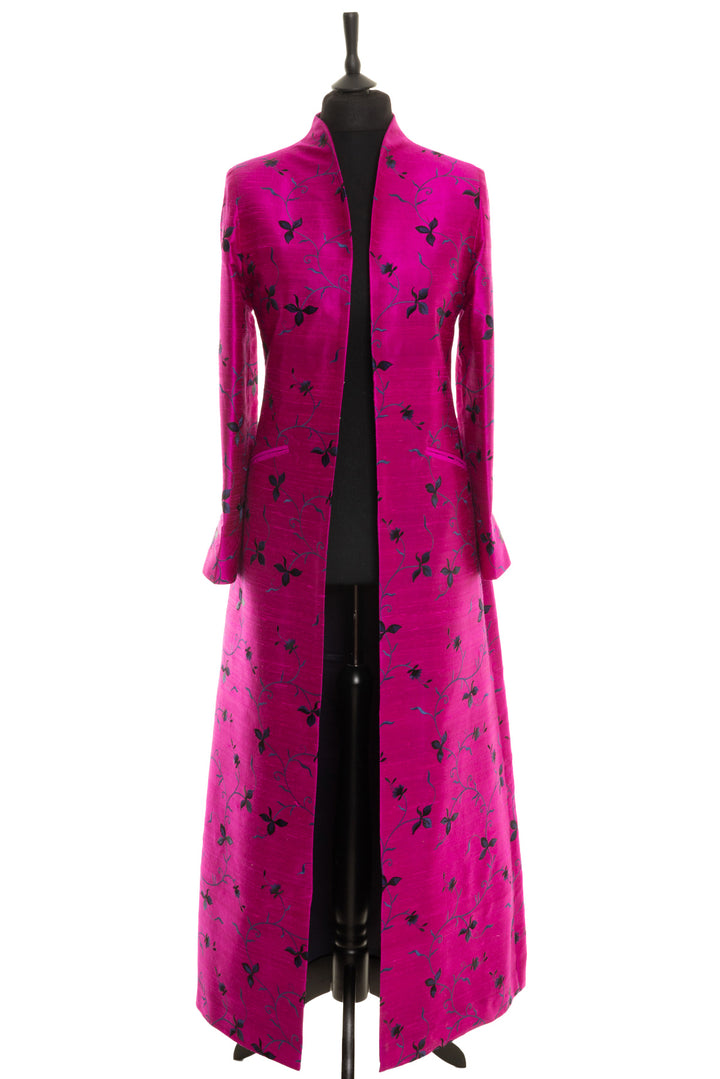 Elegant long silk coat with intricate embroidery for formal occasions. The colour of this coat is bright pink and it has black and blue floral embroidery. 