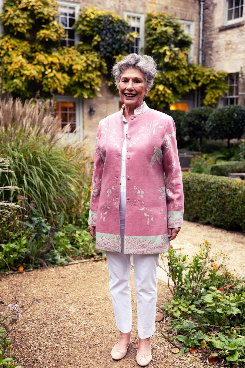 Longline pink jacket worn with white jeans and shirt. 