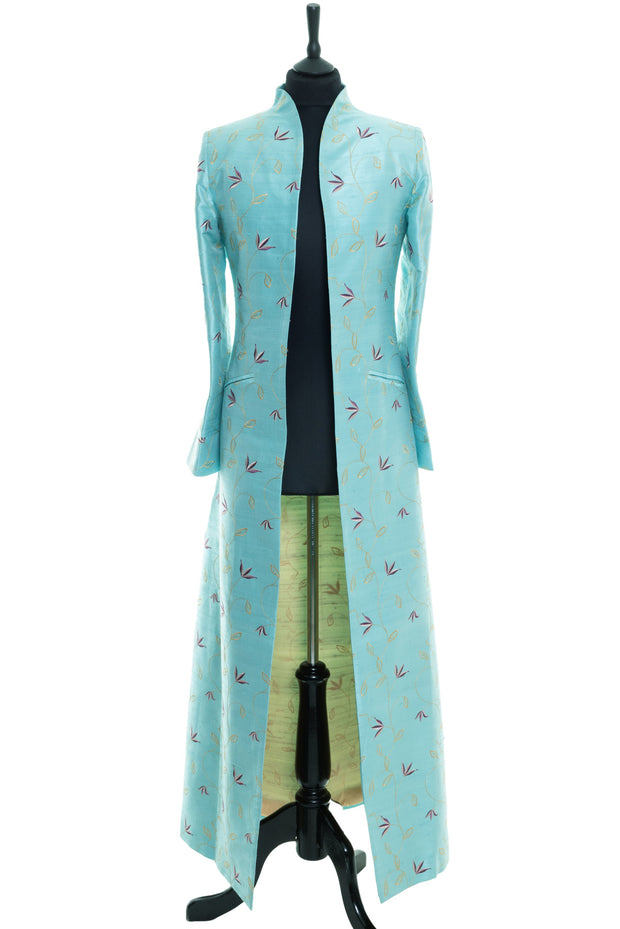 Full length women's coat in turquoise with soft floral embroidery. The coat is to be worn open and creates flattering shape on plus size women. 