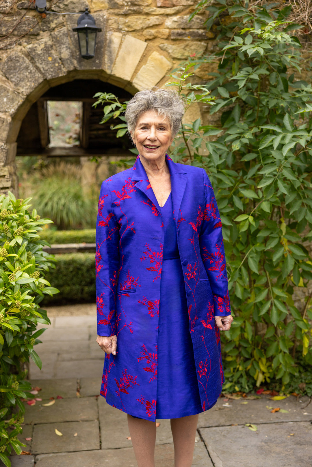 French cobalt knee length coat. Ladies blue coat with large floral red pattern. 