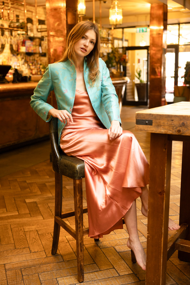 silk women's blazer with embroidered flowers worn over long silk dress in blush rose