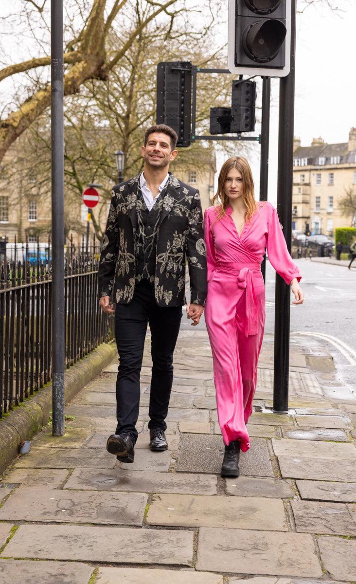 men walking in the City of Bath wearing Shibumi jacket with a young women in a pink silk Shibumi jumpsuit 