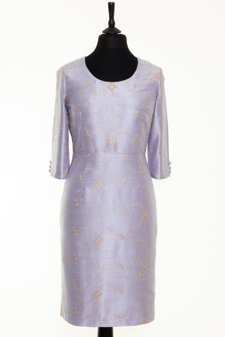 Mother of the bride dress in lilac. This round neck dress has soft golden embroidery on lilac silk. The dress has longer sleeves. 