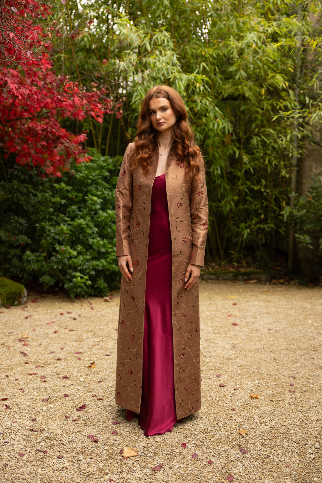 Opera coat in brown with red and yellow floral pattern. Worn over a satin silk burgundy dress. 