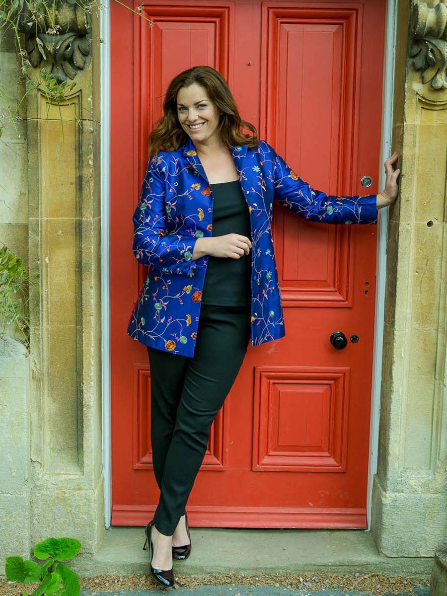 Plus size model wearing Shibumi blue floral jacket. Long jacket that is worn open with jeans. 