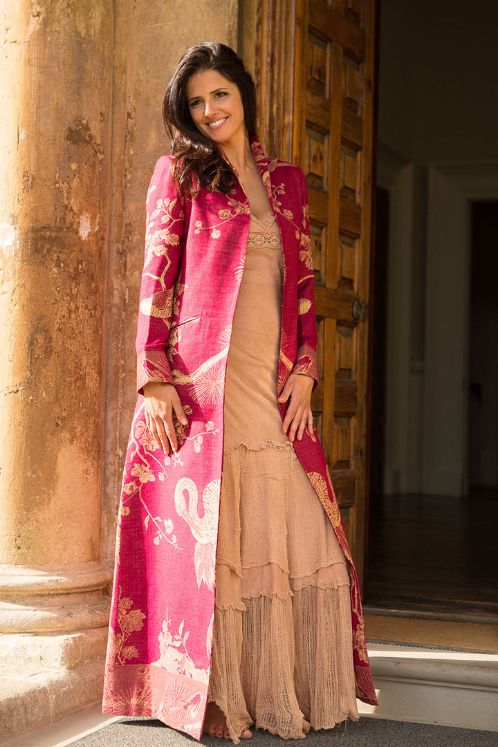 lady standing on top of the stairs wearing a statement coat in red with flowers and birds motives 