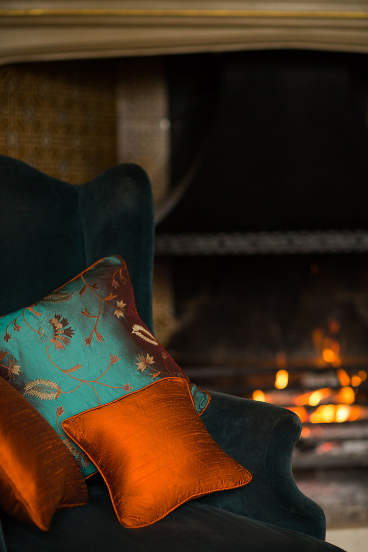 Green and orange armchair cushions. Interior design by Shibumi. 