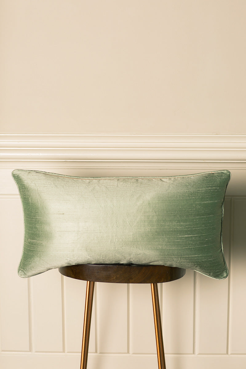 Light green silk rectangular cushion with same colour pipping. 