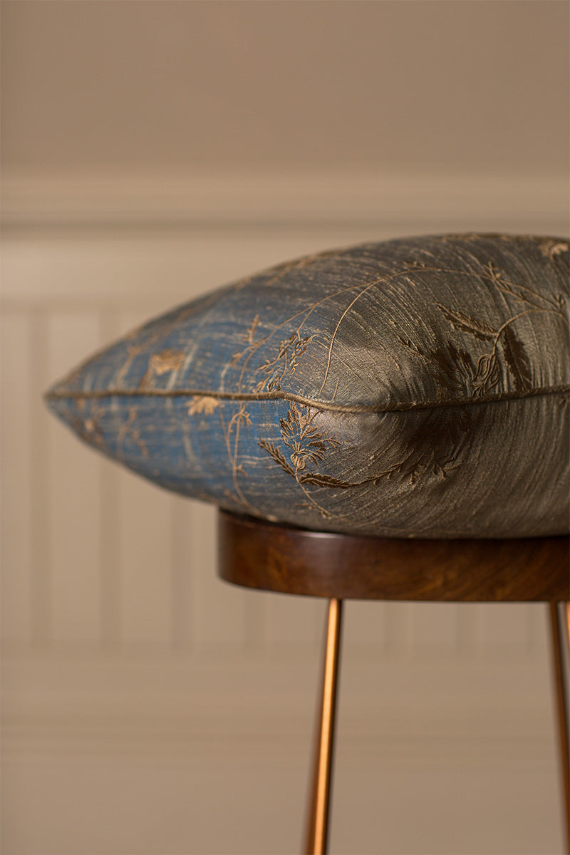 Blue large bed cushion with embroidered golden flowers. 