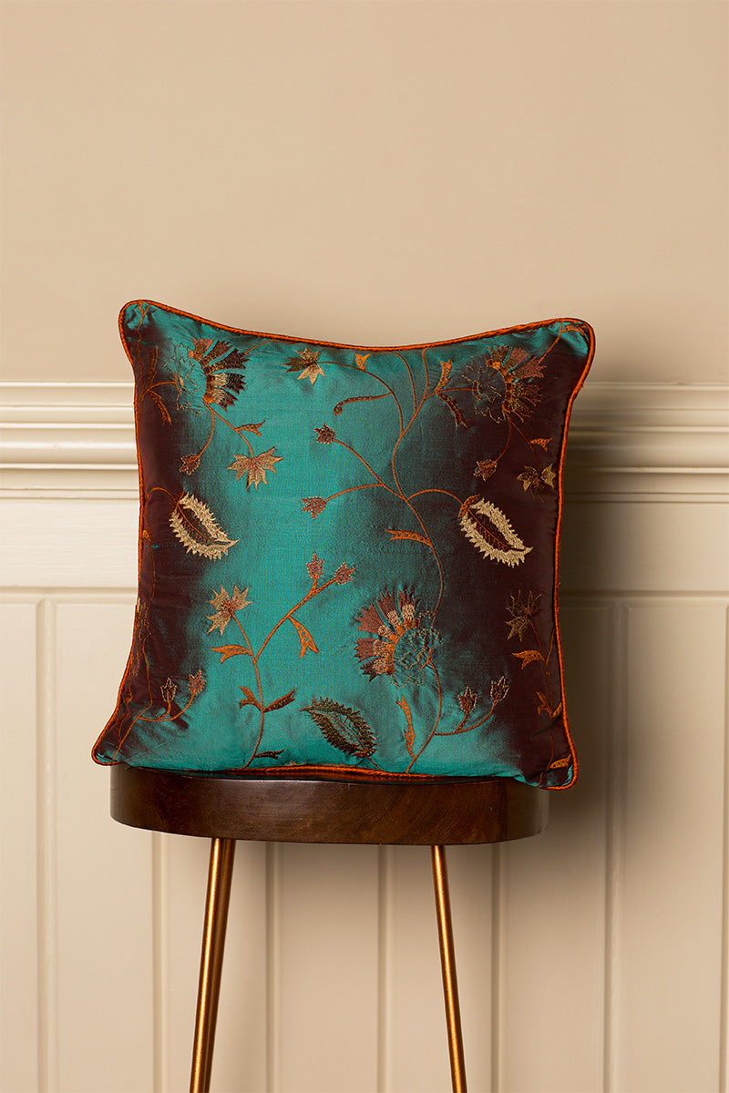 Elegant sofa cushion in green with gold floral pattern. 