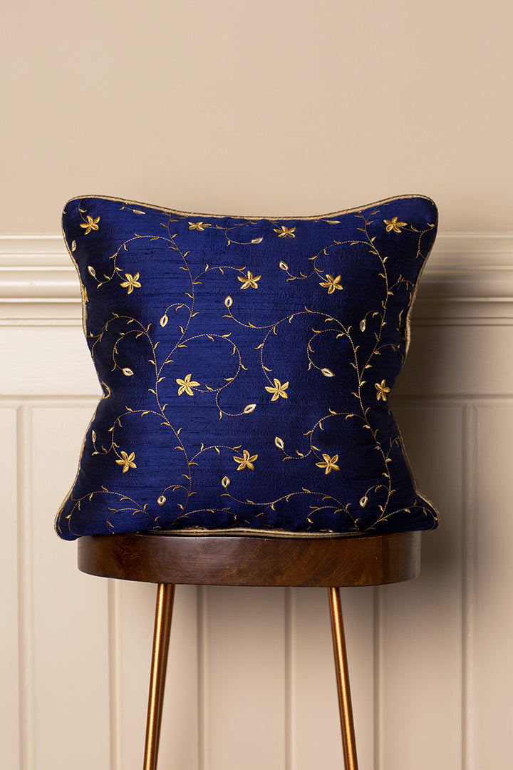 Navy blue sofa cushion with gold pattern. 